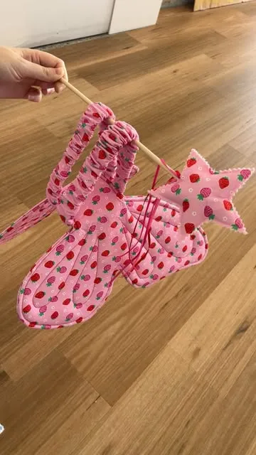 Strawberry Wishes wings and wand held up by a hand